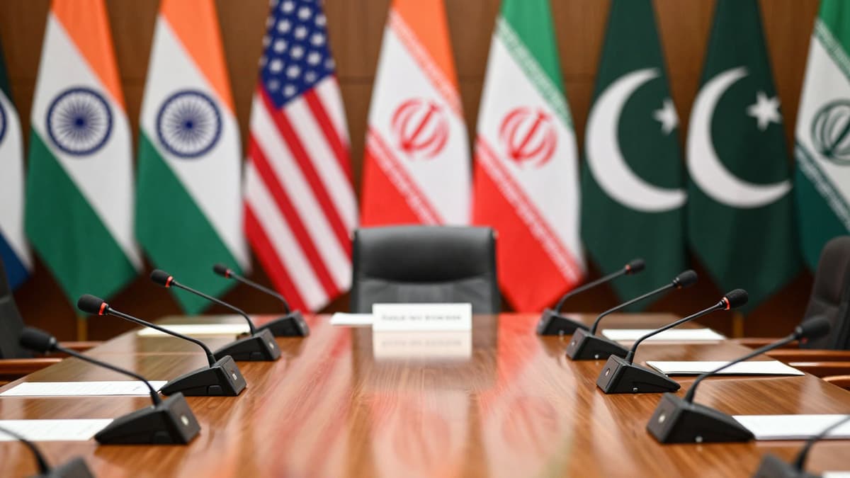 Diplomatic conference room with flags of India, US, Iran, and Pakistan symbolizing international talks.