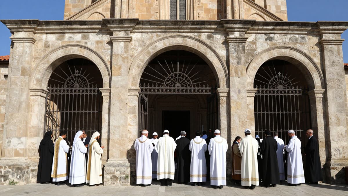 Diverse religious figures stand outside the barred gates of an ancient stone church on a sunny day.