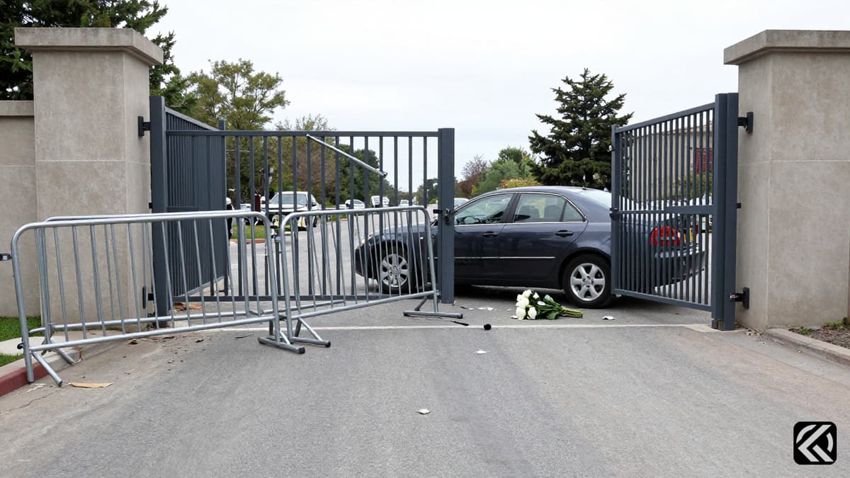 A damaged security gate and barricade outside a government building after a vehicle breach.