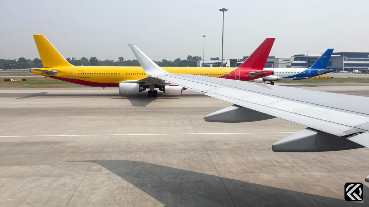 Two damaged commercial aircraft wings touching on a grey concrete taxiway at an airport.