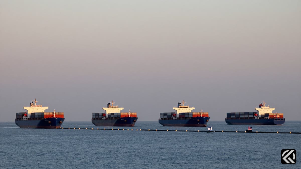 Four container ships navigating waters near a naval blockade with national flags visible against a twilight sky.
