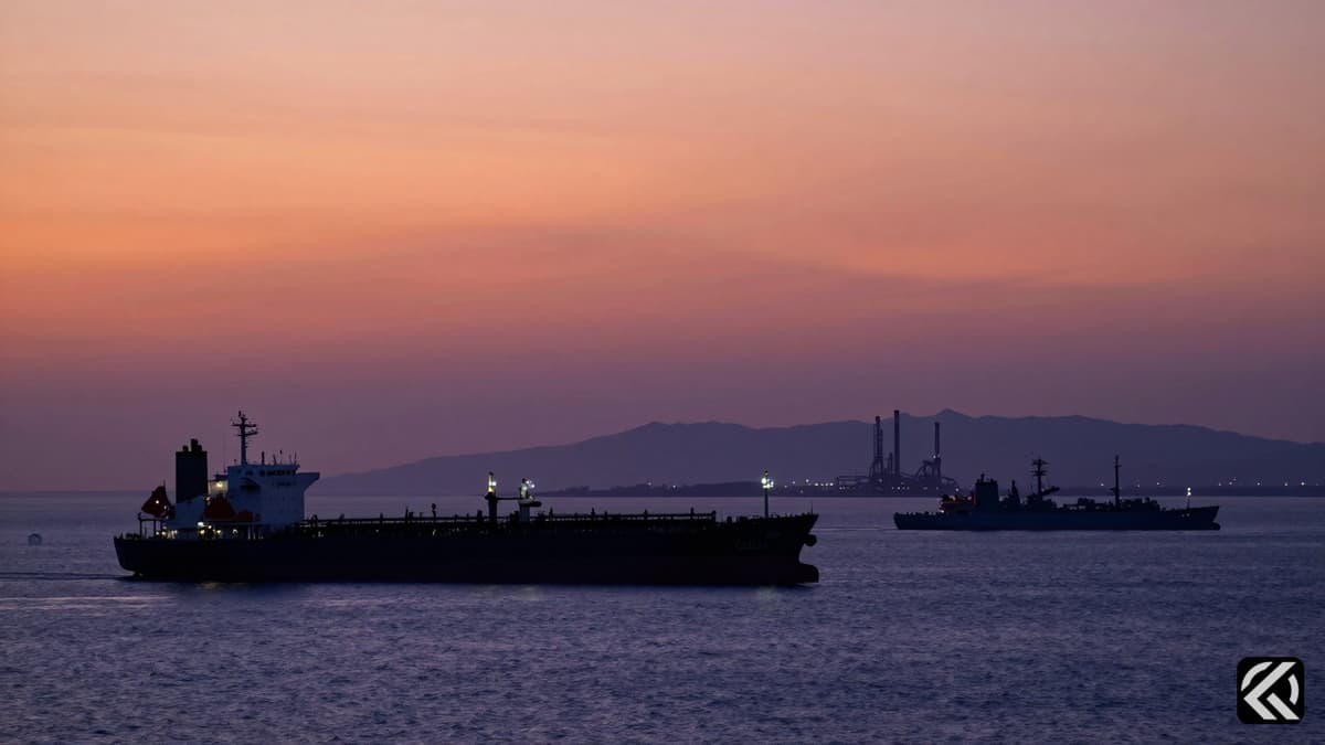 Oil tankers navigating the Strait of Hormuz at twilight with refinery silhouettes