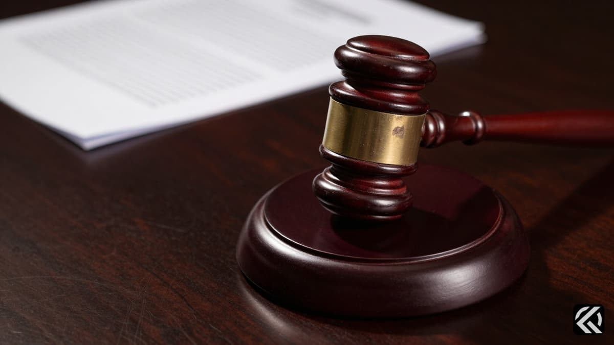A close-up of a closed wooden gavel on a desk symbolizing legal judgment