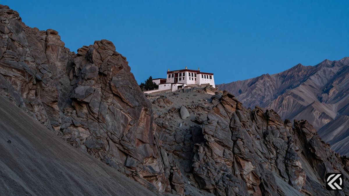 Majestic Himalayan mountains and a traditional Ladakhi monastery under a clear sky representing regional identity.