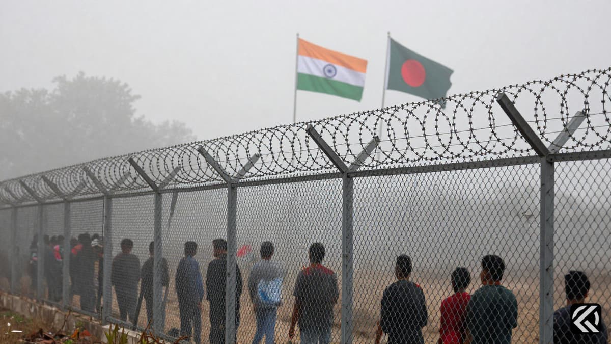 Foggy border fence with Indian and Bangladeshi flags in distance
