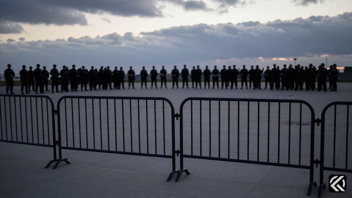 Police barricades block access to a protest site under grey skies.